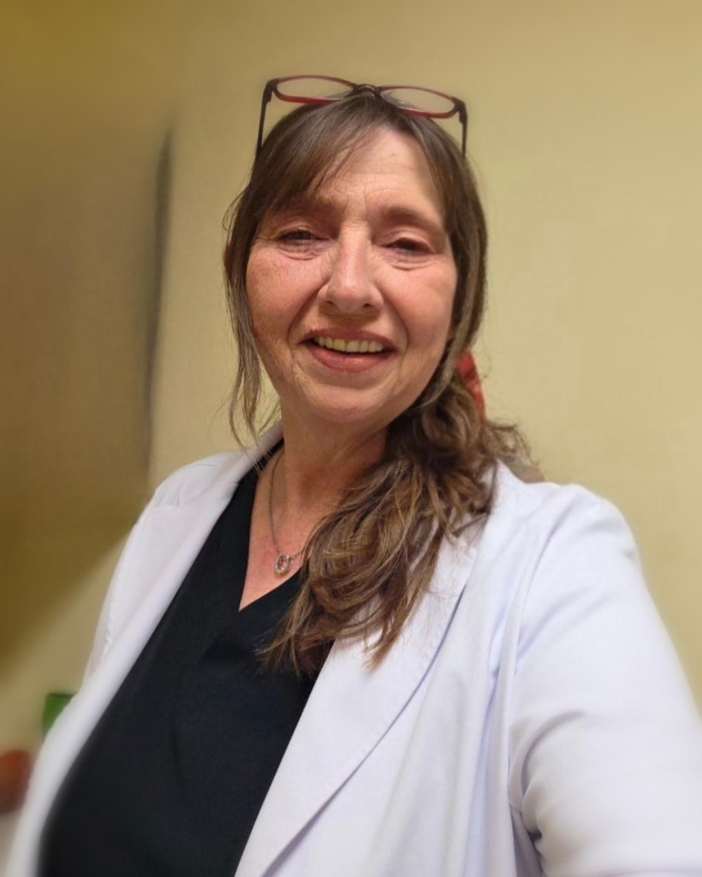 Mary Bratcher smiling warmly, glasses resting on her head
